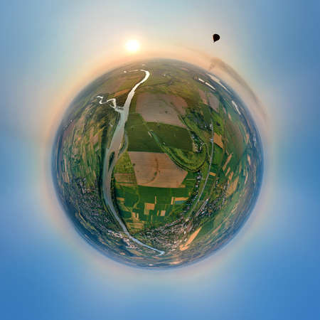 Aerial view from high altitude of little planet earth with small hot air baloon flying on orbit over...