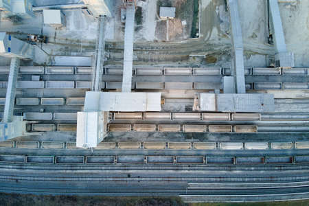 Aerial view of cargo train loaded with crushed stone materials at mining factory. Railway...