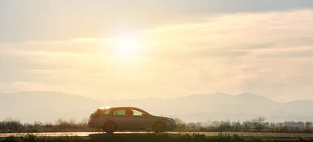 Car driving fast on intercity road at sunset. Highway traffic in eveningの写真素材