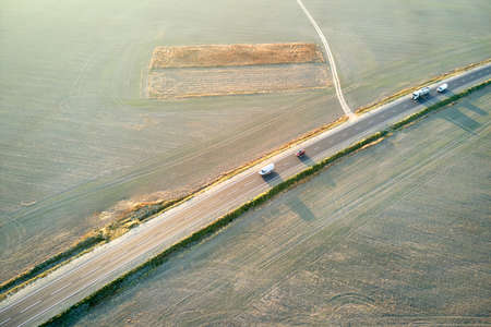Aerial view of intercity road with fast driving cars at sunset. Top view from drone of highway...