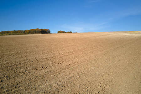 Plowed agricultural field with cultivated fertile soil prepared for planting crops in spring