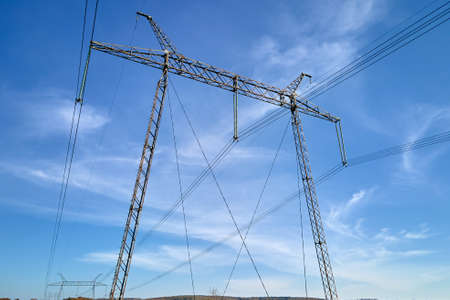 Steel pillar with high voltage electric power lines delivering electrical energy through cable wires...
