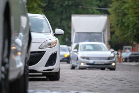 Cars parked in line on city street side. Urban traffic concept