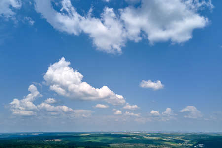 Aerial landscape view of clear blue sky over green cultivated agricultural fields with growing crops...