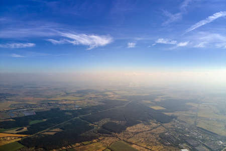 Aerial view of farm fields and distant scattered houses in rural area