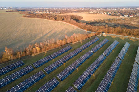 Aerial view of large sustainable electrical power plant with rows of solar photovoltaic panels for...