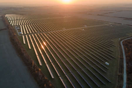Aerial view of large sustainable electrical power plant with rows of solar photovoltaic panels for...
