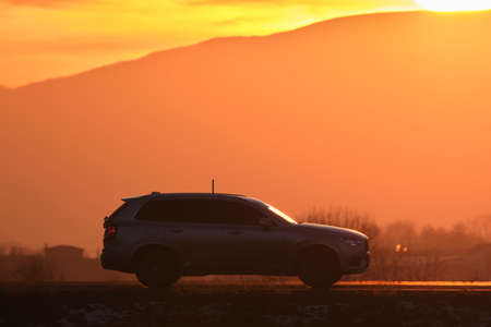 SUV car driving fast on intercity road at sunset. Highway traffic in eveningの写真素材