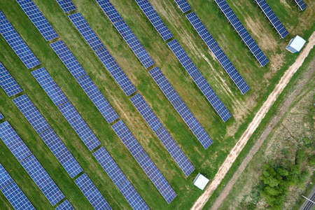 Aerial view of big sustainable electric power plant with many rows of solar photovoltaic panels for...