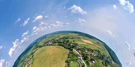 Aerial view from high altitude of little planet earth with small village houses and distant green...