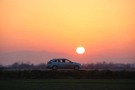 Car driving fast on intercity road at sunset. Highway traffic in eveningの写真素材