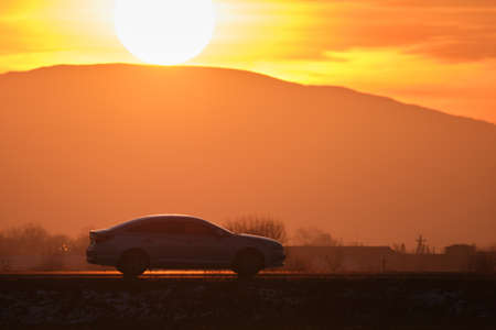 Car driving fast on intercity road at sunset. Highway traffic in evening