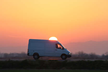 Small cargo van driving on highway hauling goods. Delivery transportation and logistics concept