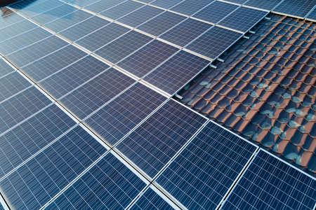 Aerial view building roof with rows of blue solar photovoltaic panels for producing clean ecological electric energy. Renewable electricity with zero emission conceptの写真素材