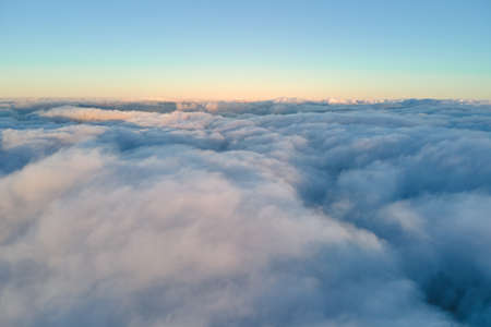 Aerial view from high altitude of earth covered with puffy rainy clouds forming before rainstormの写真素材