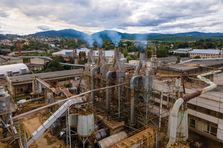 Aerial view of wood processing plant with smokestack from production process polluting environment at factory manufacturing yardの写真素材