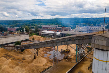 Aerial view of wood processing plant with smokestack from production process polluting environment at factory manufacturing yardの写真素材