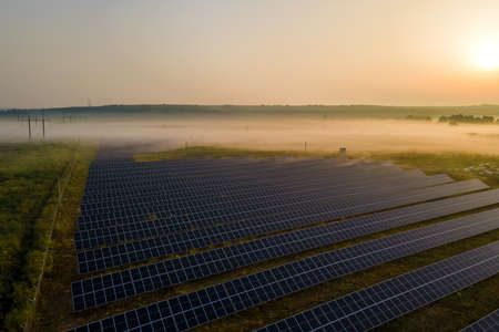 Aerial view of large sustainable electrical power plant with rows of solar photovoltaic panels for...