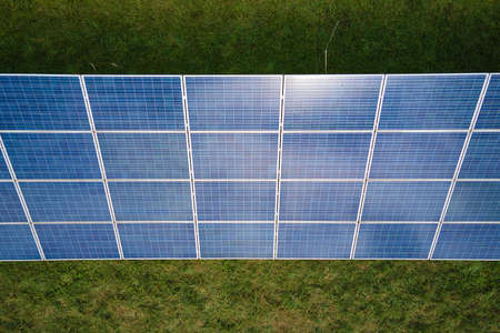 Aerial view of big sustainable electric power plant with many rows of solar photovoltaic panels for...