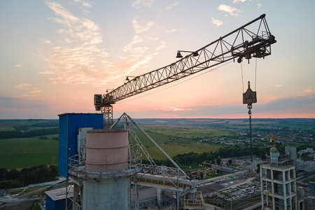 Aerial view of cement factory under construction with high concrete plant structure and tower cranes...