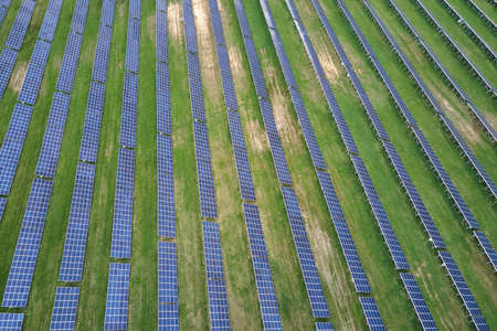 Aerial view of big sustainable electric power plant with many rows of solar photovoltaic panels for...