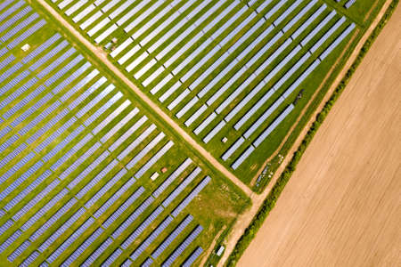 Aerial view of big sustainable electric power plant with many rows of solar photovoltaic panels for...