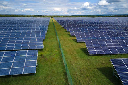 Aerial view of big sustainable electric power plant with many rows of solar photovoltaic panels for...