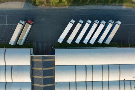 Aerial view of goods warehouses and logistics center in industrial city zone from aboveの写真素材