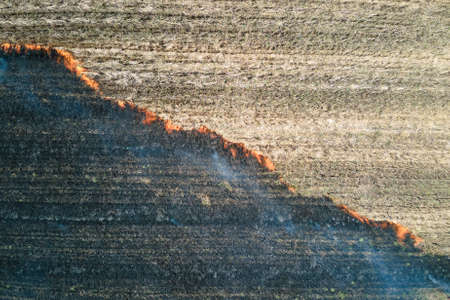 Aerial view of grassland field burning with red fire during dry season. Natural disaster and climate change conceptの写真素材