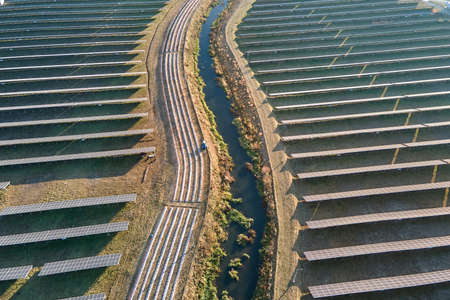 Aerial view of large sustainable electrical power plant with rows of solar photovoltaic panels for producing clean ecological electric energy. Renewable electricity with zero emission conceptの写真素材