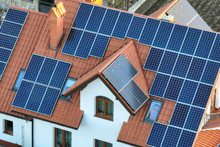 Residential house with rooftop covered with solar photovoltaic panels for producing of clean...