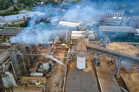 Aerial view of wood processing plant with smokestack from production process polluting environment...