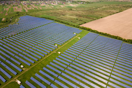 Aerial view of big sustainable electric power plant with many rows of solar photovoltaic panels for...