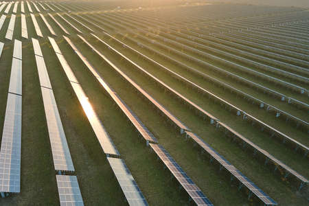 Aerial view of large sustainable electrical power plant with rows of solar photovoltaic panels for...