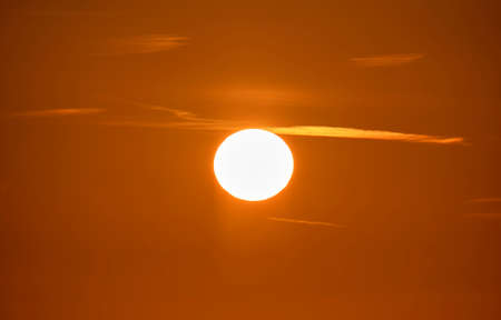 Beautiful sky view at sunset. Big white sun shining brightly in yellow evening skyの写真素材