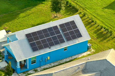 Aerial view building roof with rows of blue solar photovoltaic panels for producing clean ecological...