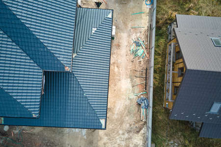 Aerial view of house roof top covered with ceramic shingles. Tiled covering of building under constructionの写真素材