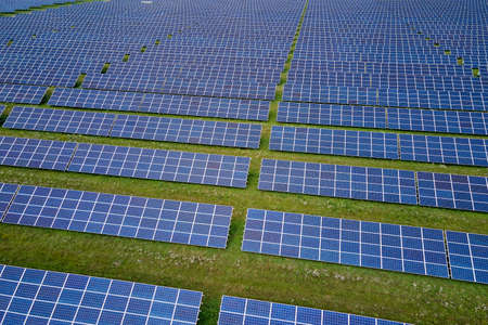 Aerial view of large sustainable electrical power plant with rows of solar photovoltaic panels for...