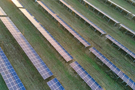 Aerial view of large sustainable electrical power plant with rows of solar photovoltaic panels for...