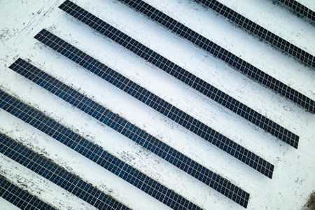 Aerial view of sustainable electrical power plant with solar photovoltaic panels covered with snow in winter for producing clean energy. Concept of low effectivity of renewable electricity in northの写真素材
