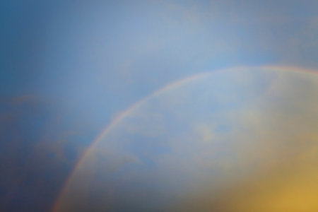 Colorful round rainbow against blue evening sky after heavy thunderstorm