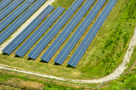 Aerial view of big sustainable electric power plant with many rows of solar photovoltaic panels for...