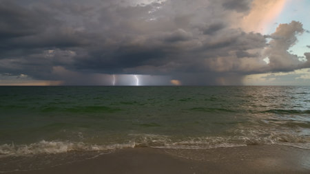 Dark stormy clouds forming on gloomy sky during heavy rainfall season over sea surface in eveningの写真素材