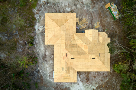 Aerial view of suburban private house with wooden roof frame under construction in Florida quiet rural areaの写真素材