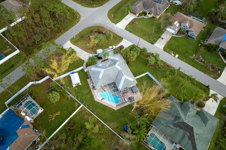 Top view of leaking house roof covered with protective tarp sheets against rain water leaks until...