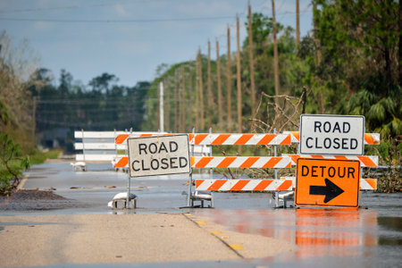 Road closed for roadworks and danger of flooding with warning signs blocking driving of carsの写真素材
