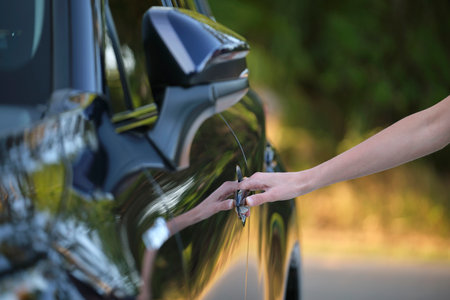 Closeup of driver hand opening car front door