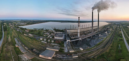 Aerial view of coal power plant high pipes with black smoke moving upwards polluting atmosphere at sunset. Production of electrical energy with fossil fuel conceptの写真素材