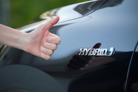 Purchaser hand showing thumb up sign at hybrid car new effective vehicleの写真素材