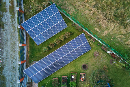 Solar photovoltaic panels mounted on stand-alone frame on backyard ground for generating of clean...